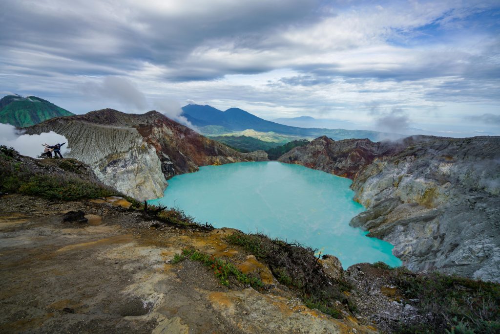 A breathtaking view of the turquoise Ijen Crater Lake surrounded by rugged mountains in Indonesia.